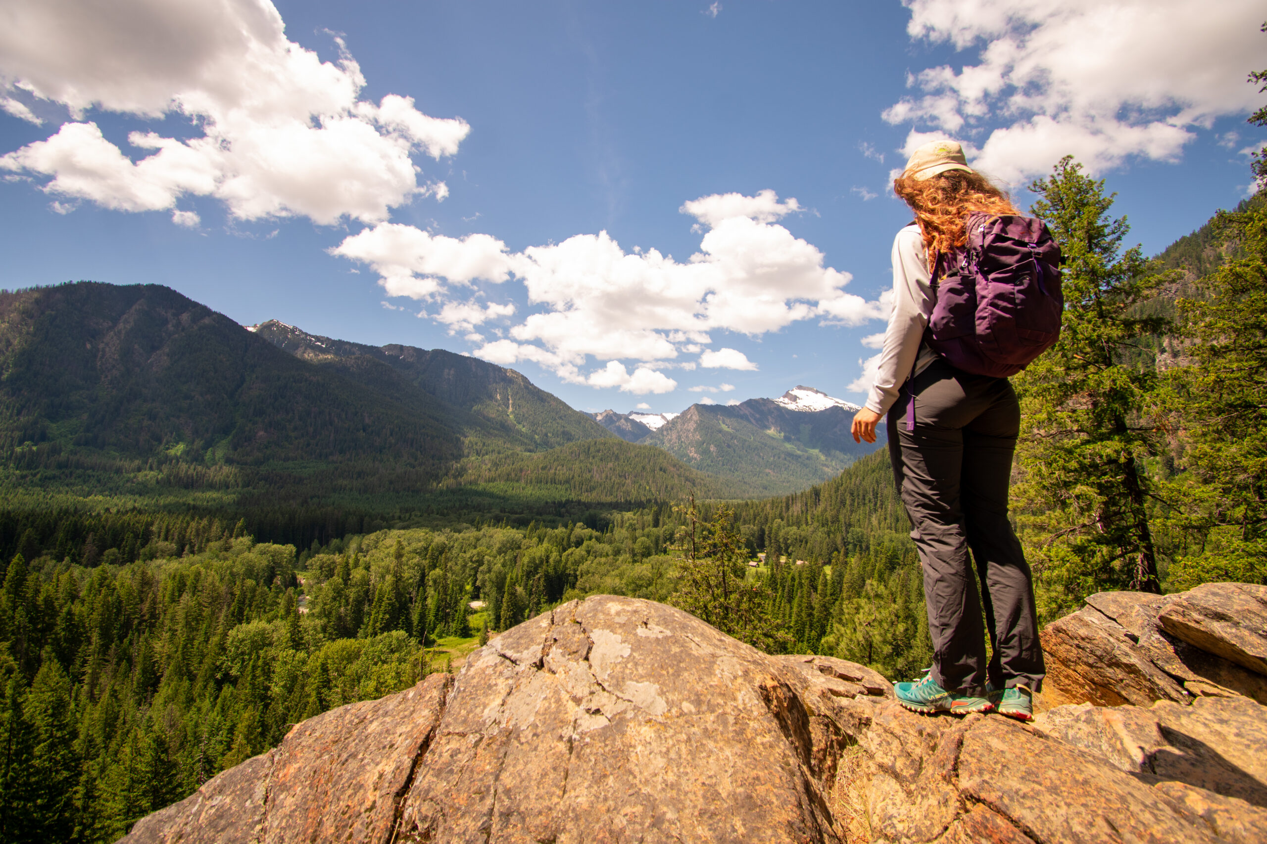 Adventure Scientists volunteer wearing a Topiku hat during conservation fieldwork in a remote Pacific Northwest forest.